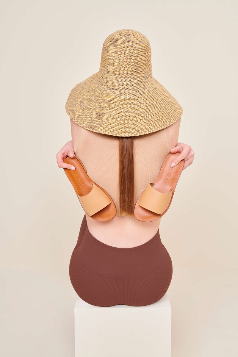 Model wearing the handmade Rock women's slip-on leather sandals in brown insole with tan straps / TAN
